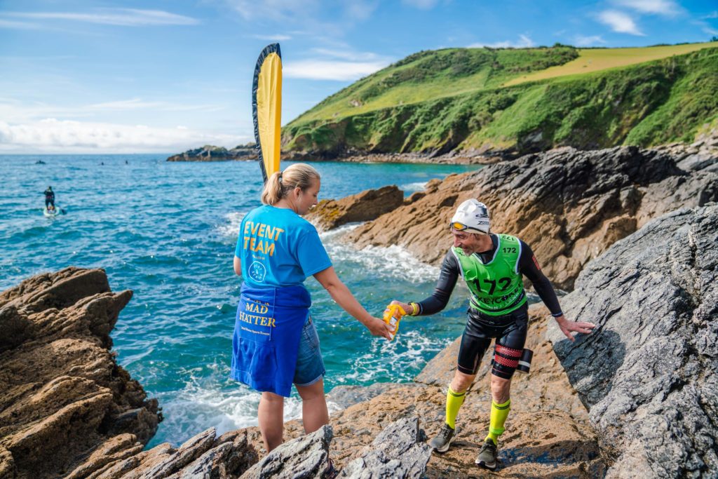 event team crew handing out food to competitor in hokey cokey swimrun